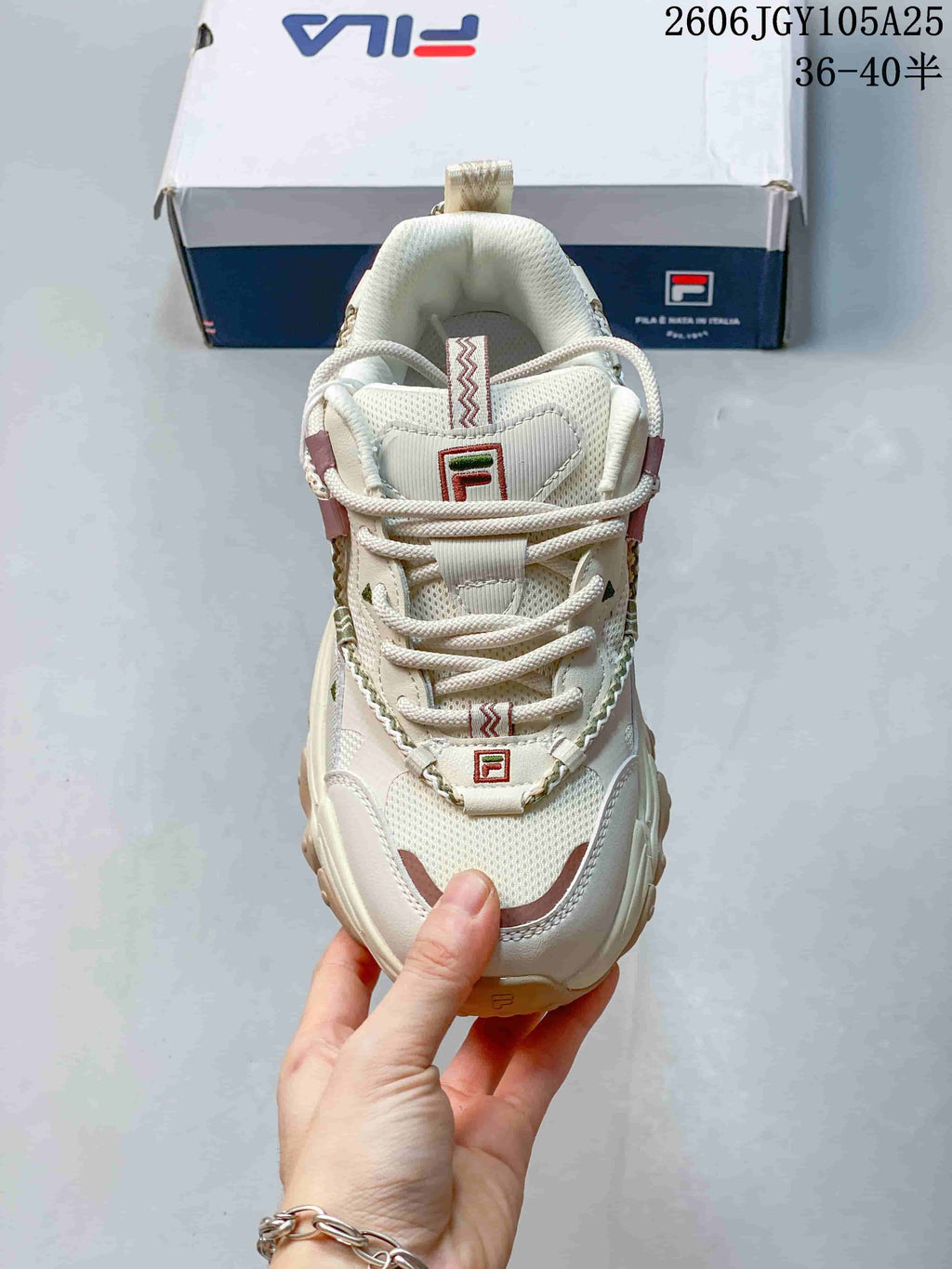 Front view of a cream FILA Fusion sneaker with lace-up fastening