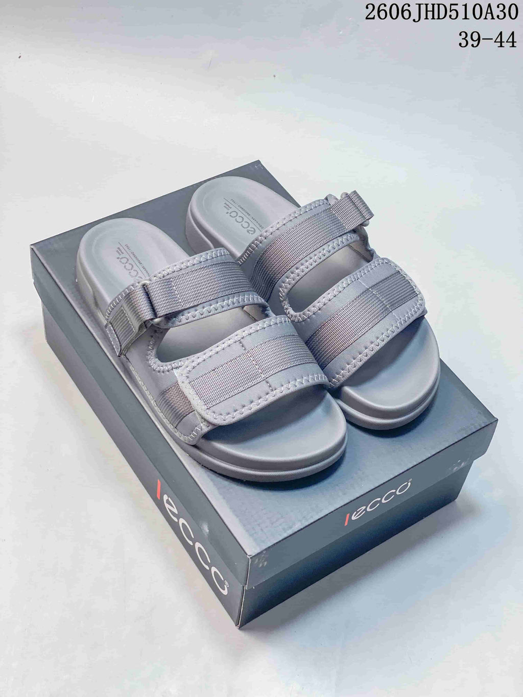 Pair of grey ECCO sandals with two adjustable straps, shown on a branded box