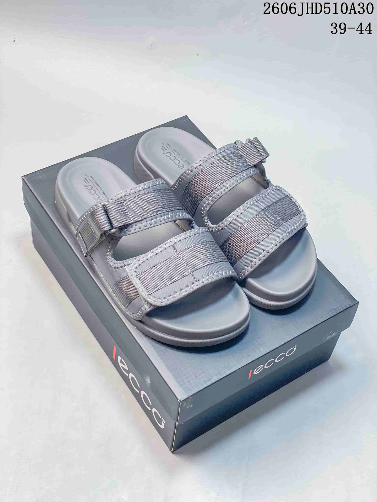Pair of grey ECCO sandals with two adjustable straps, shown on a branded box