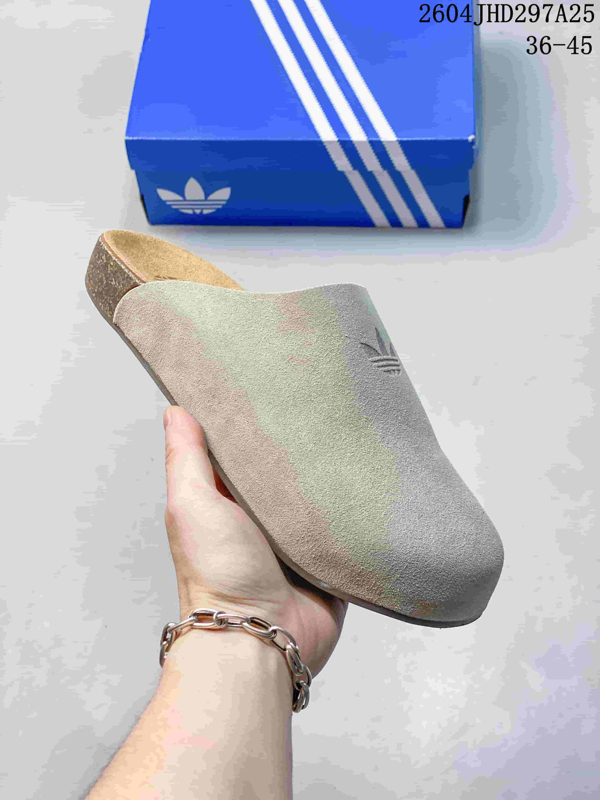 Close-up side view of a light beige closed-toe Adimule slide showing its textured upper and contoured sole.