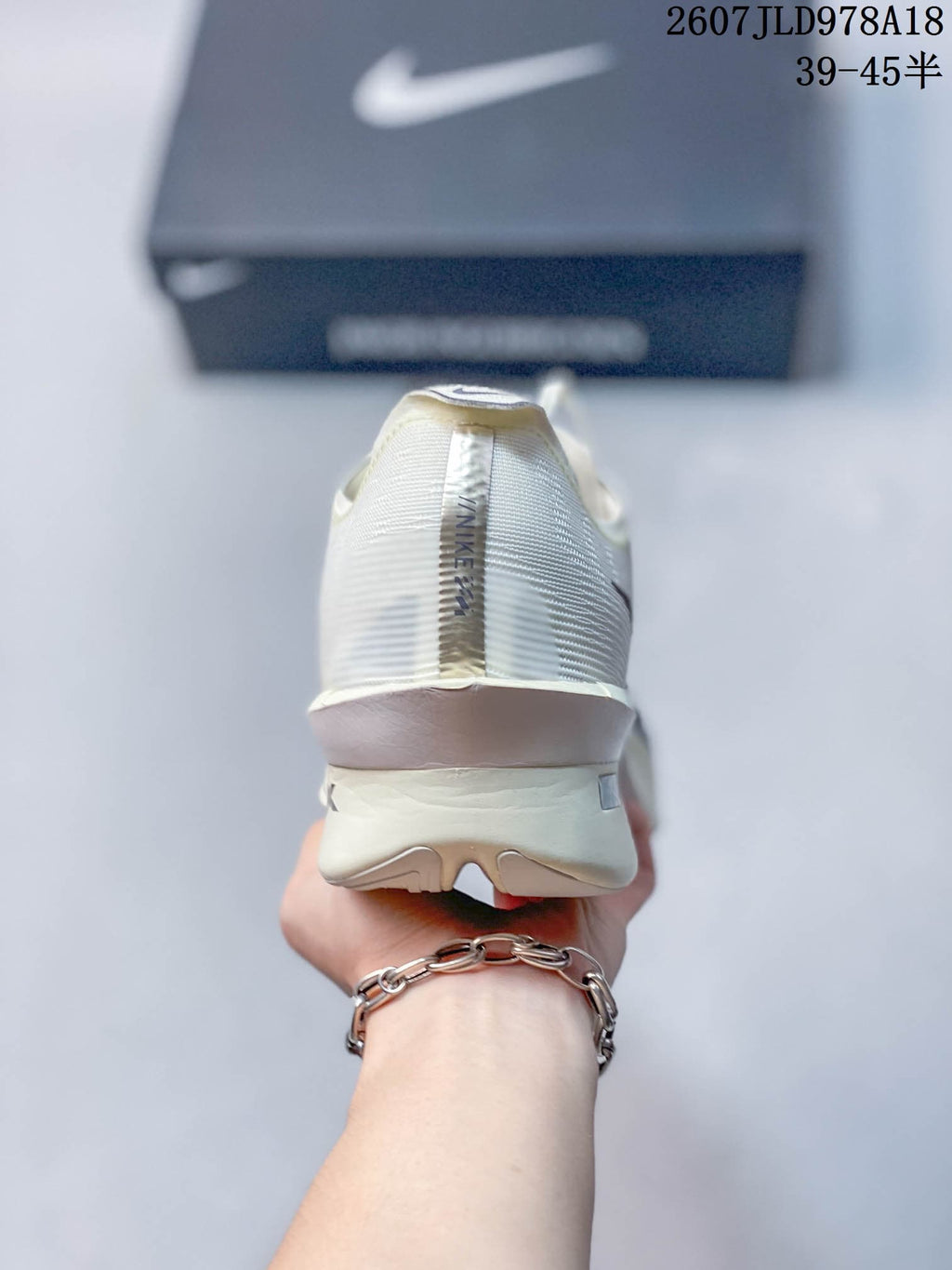Rear view of the white Nike Vaporfly shoe showing the heel construction and vertical Nike branding.