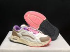 Angled view of one sneaker beside its outsole, showing the pink and black tread pattern and layered upper panels.