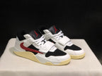 Three-quarter view of the pair highlighting the white uppers, black panels, red accents, and cream soles.