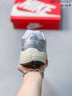 Rear view showing the padded heel, layered silver detailing, and textured cream midsole.