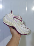 Angled close-up of white Balenciaga Jett sneakers with purple laces, layered panels, and a thick sculpted sole.