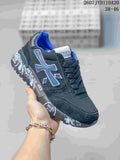 Black Premiata low-top sneaker with blue side detail and graphic printed midsole.