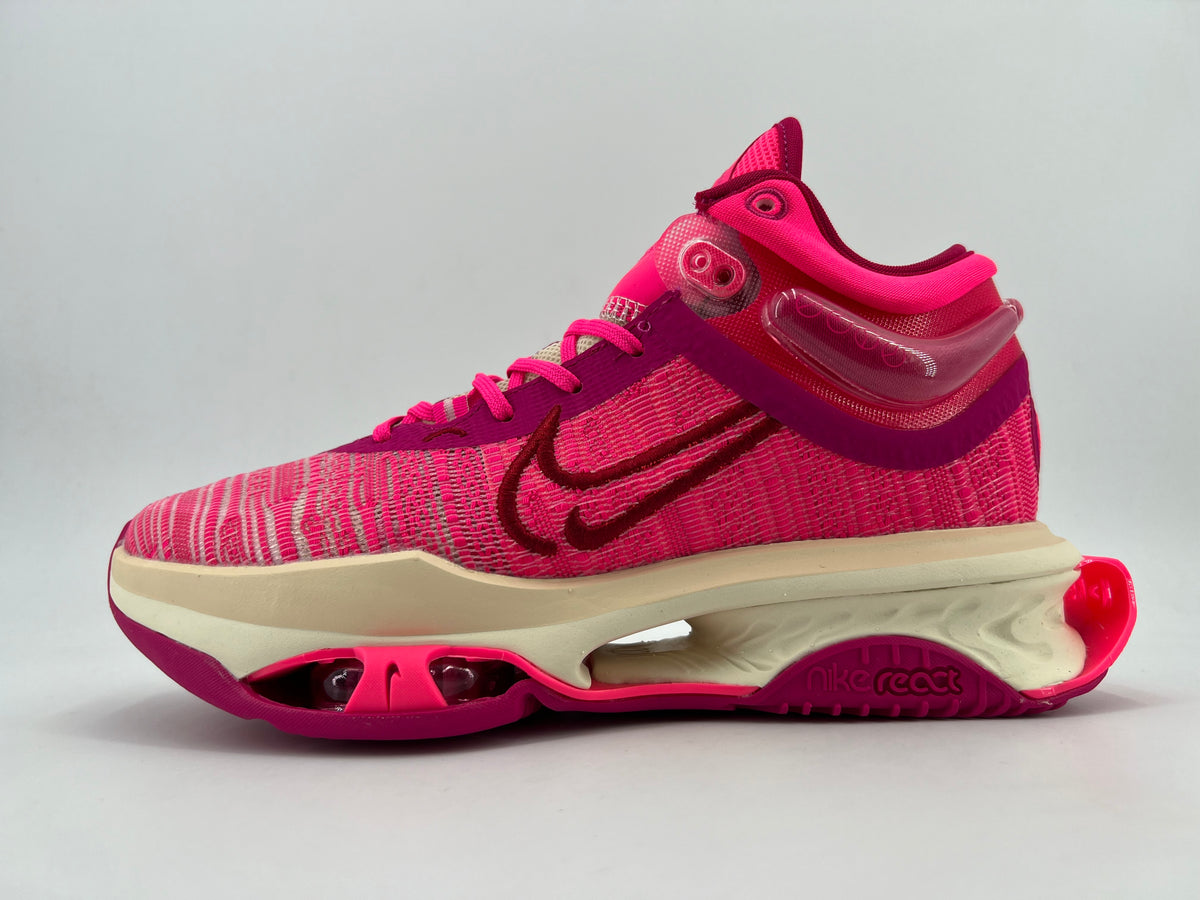 Side view of a pink patterned Nike React sneaker with dark magenta accents, cream-colored midsole, and magenta outsole.