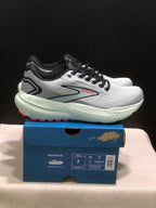 Side view of the Brooks Glycerin 21 sneakers showing the gray upper, black overlays, red branding, and light-colored midsole.