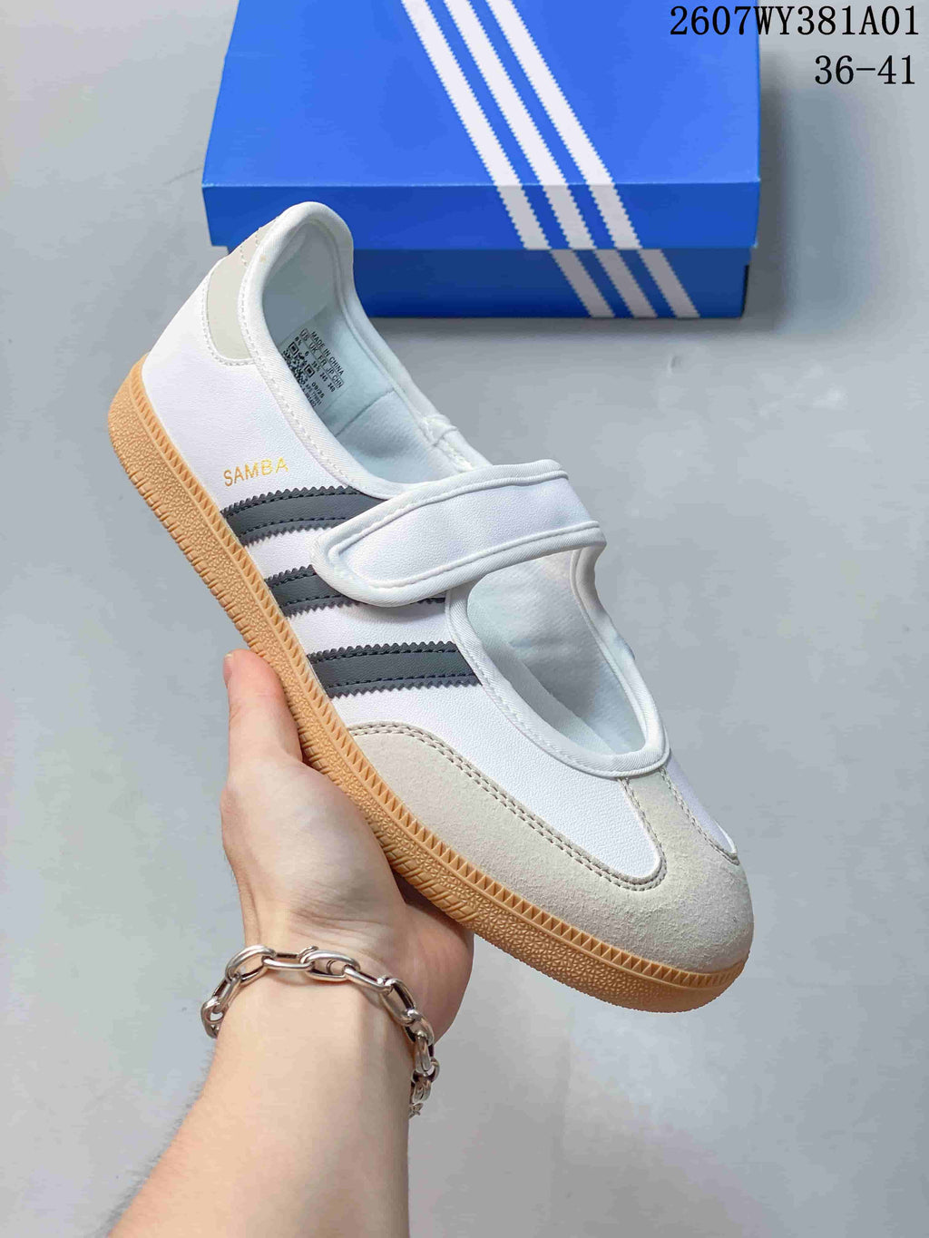 Angled side view of the Samba Jane sneaker with its strap, grey stripes and gum-colored sole