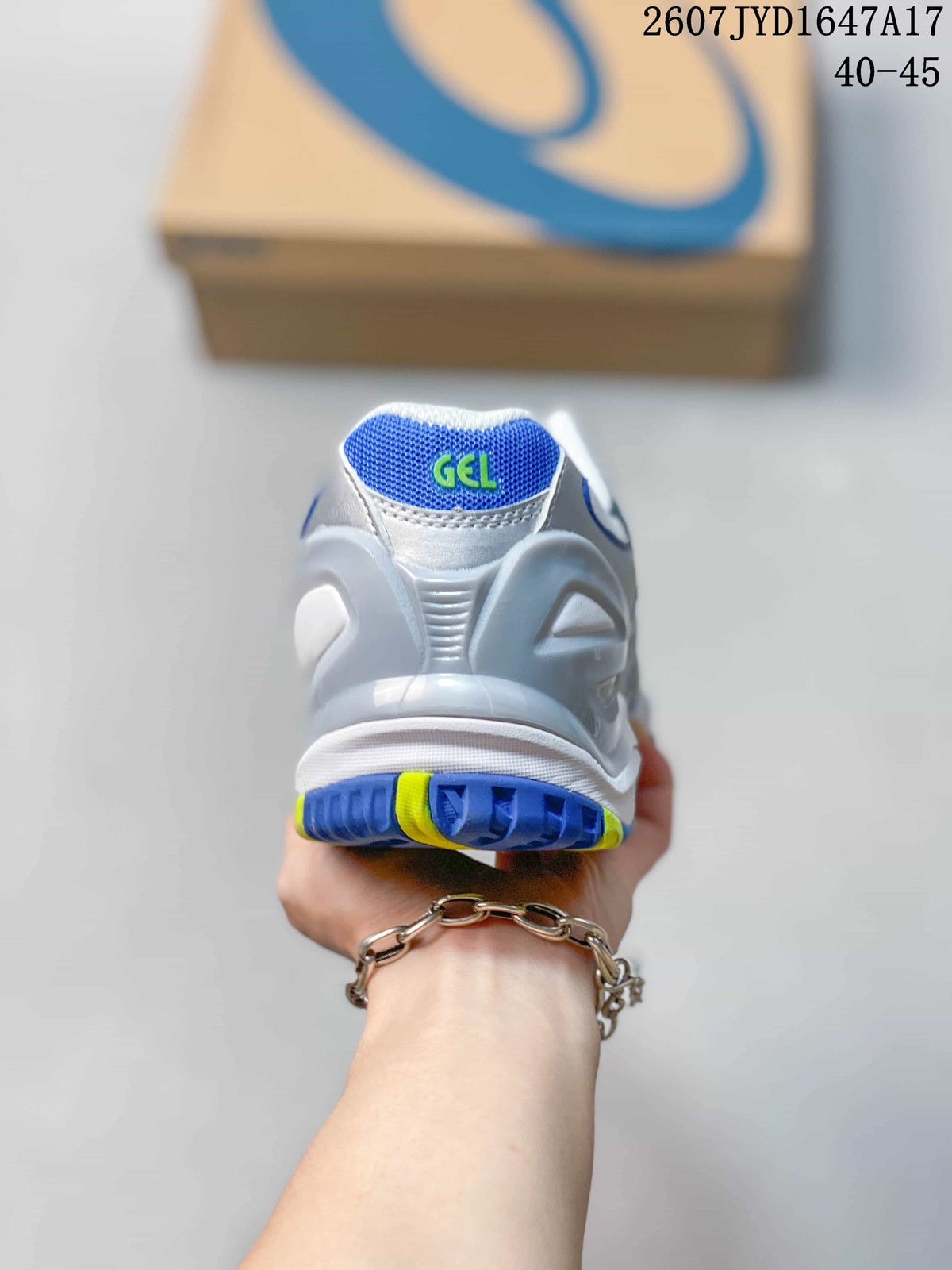 Rear view of the white tennis shoe showing the padded heel, GEL branding and blue-and-neon-yellow outsole accents.