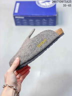 Side view of a gray clog showing the felt-look upper, contoured footbed, textured outsole, and heel detail.