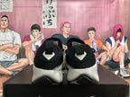 Rear view of black Nike sneakers with pale gray sculpted heels and a basketball-themed display behind them.