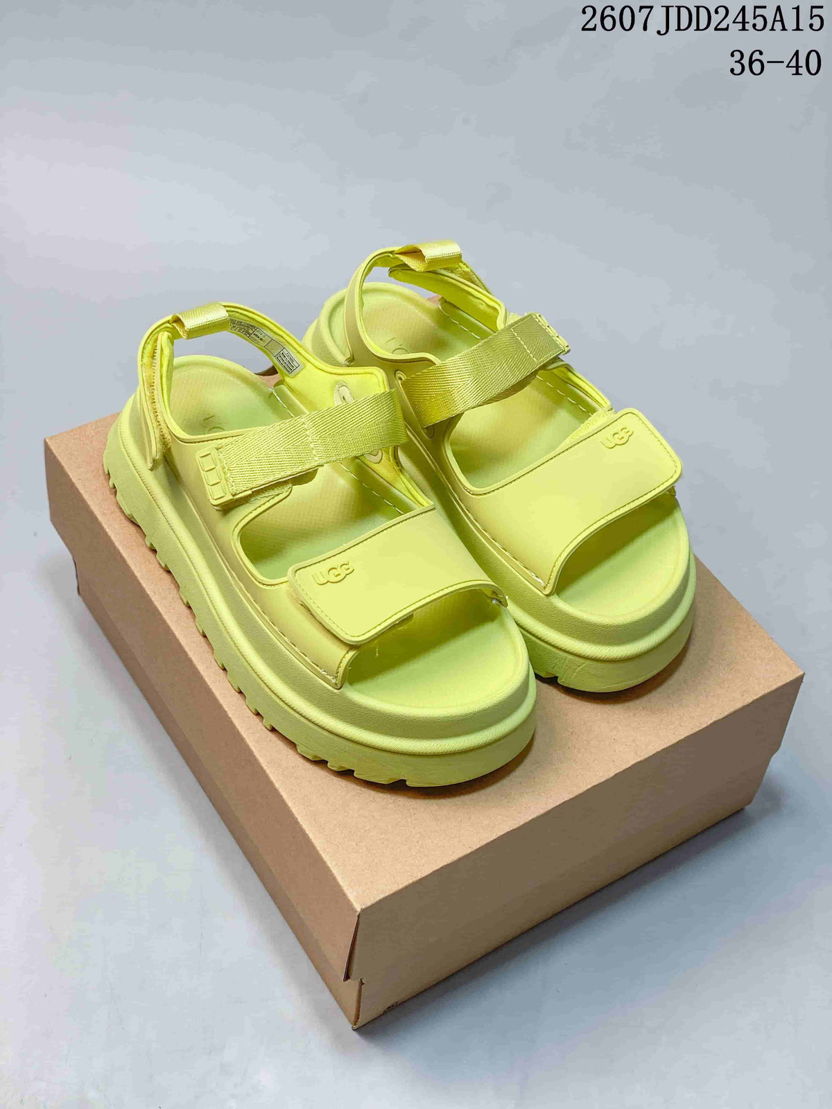Pair of bright lime green UGG GoldenGlow platform sandals displayed on a cardboard box.