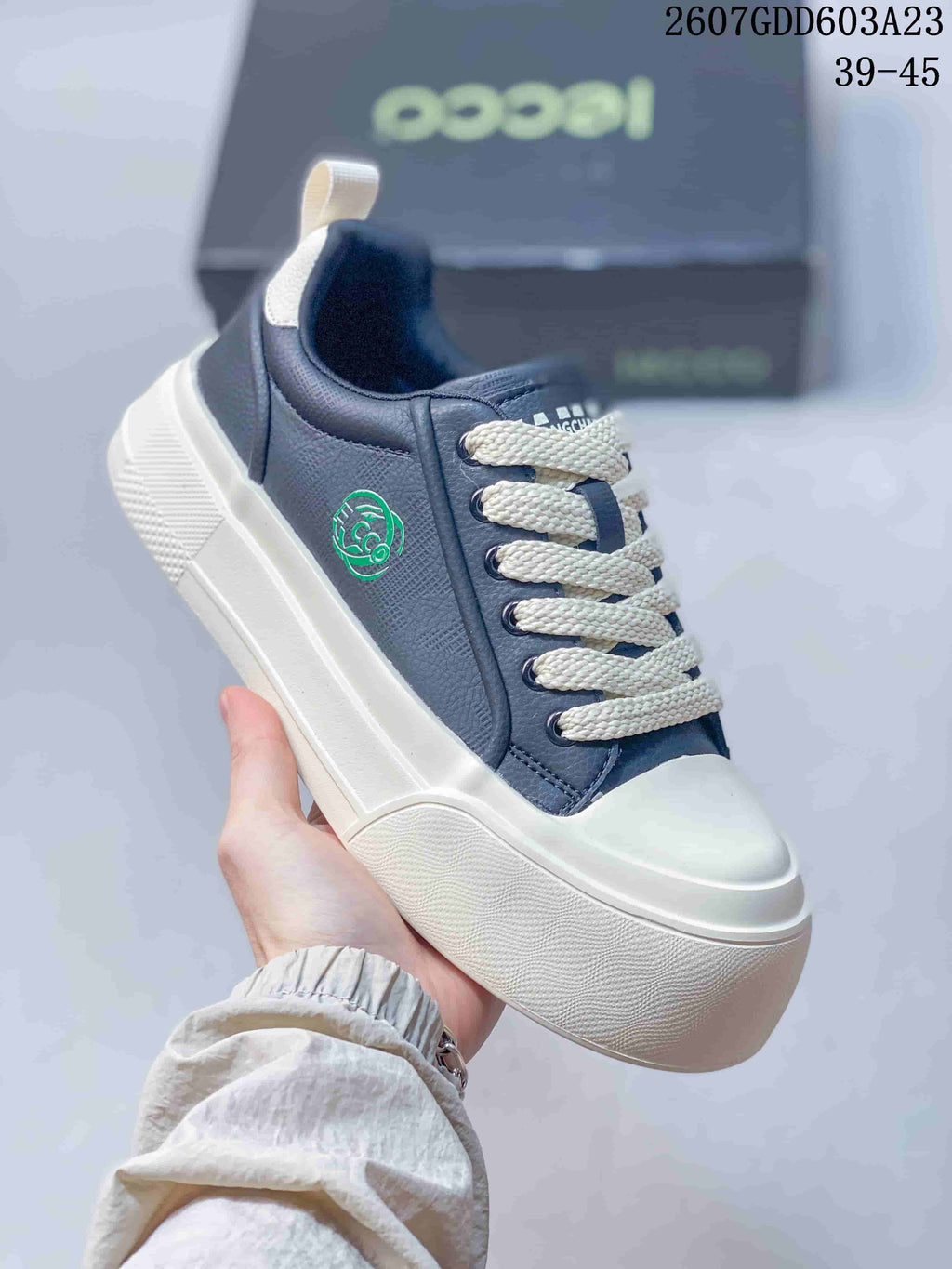 Angled side view showing the navy upper, cream laces, side emblem, and white platform-style sole.