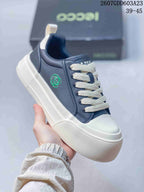 Angled side view showing the navy upper, cream laces, side emblem, and white platform-style sole.