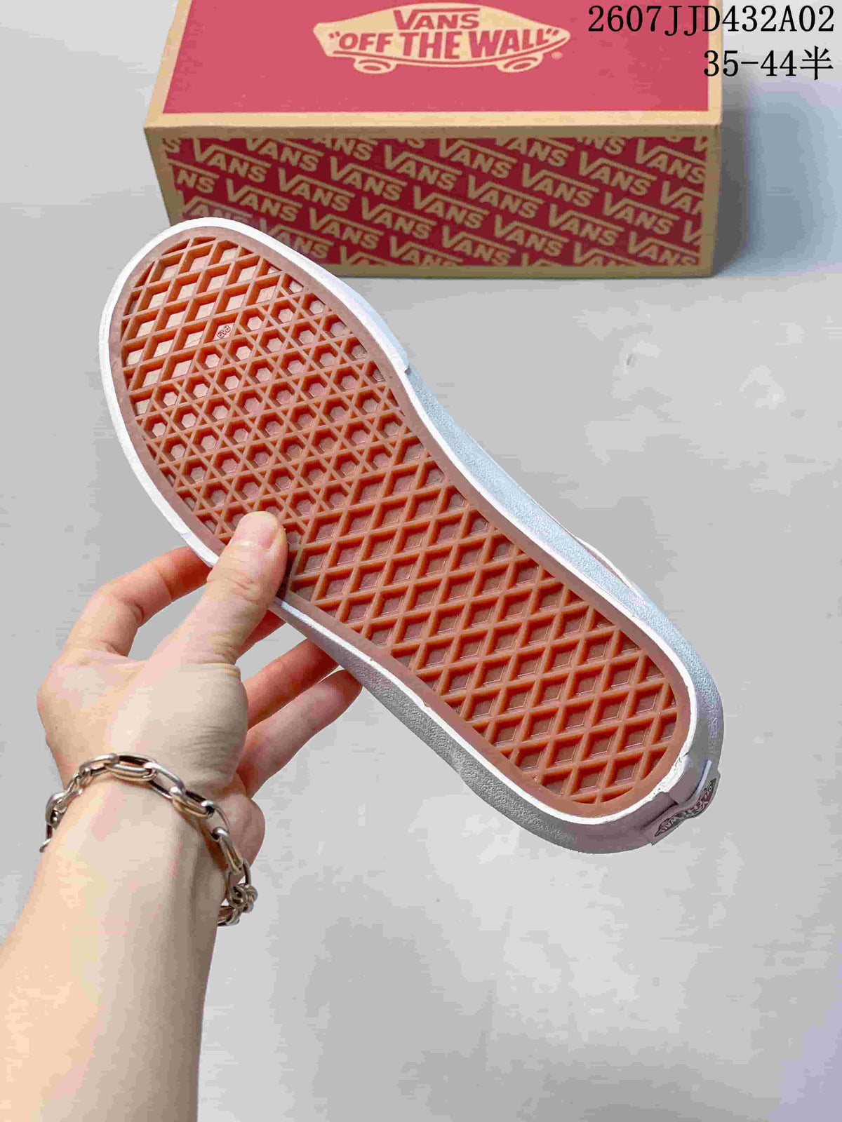 Close-up of the patterned rubber outsole on a pink and white sneaker