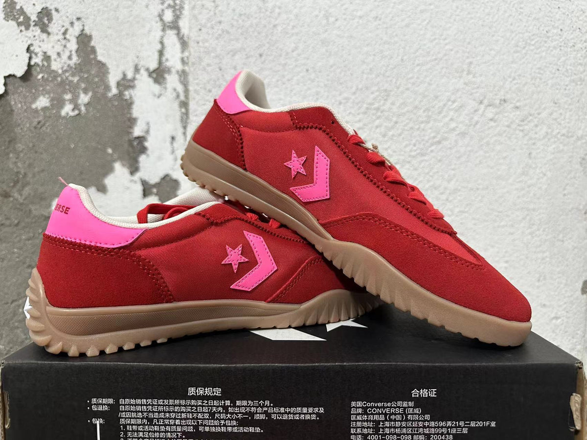 Pair of red and pink Converse low-top sneakers shown at an angle.