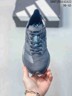 Top view showing the dark gray textured upper, laces, padded tongue, and turquoise tongue detail.
