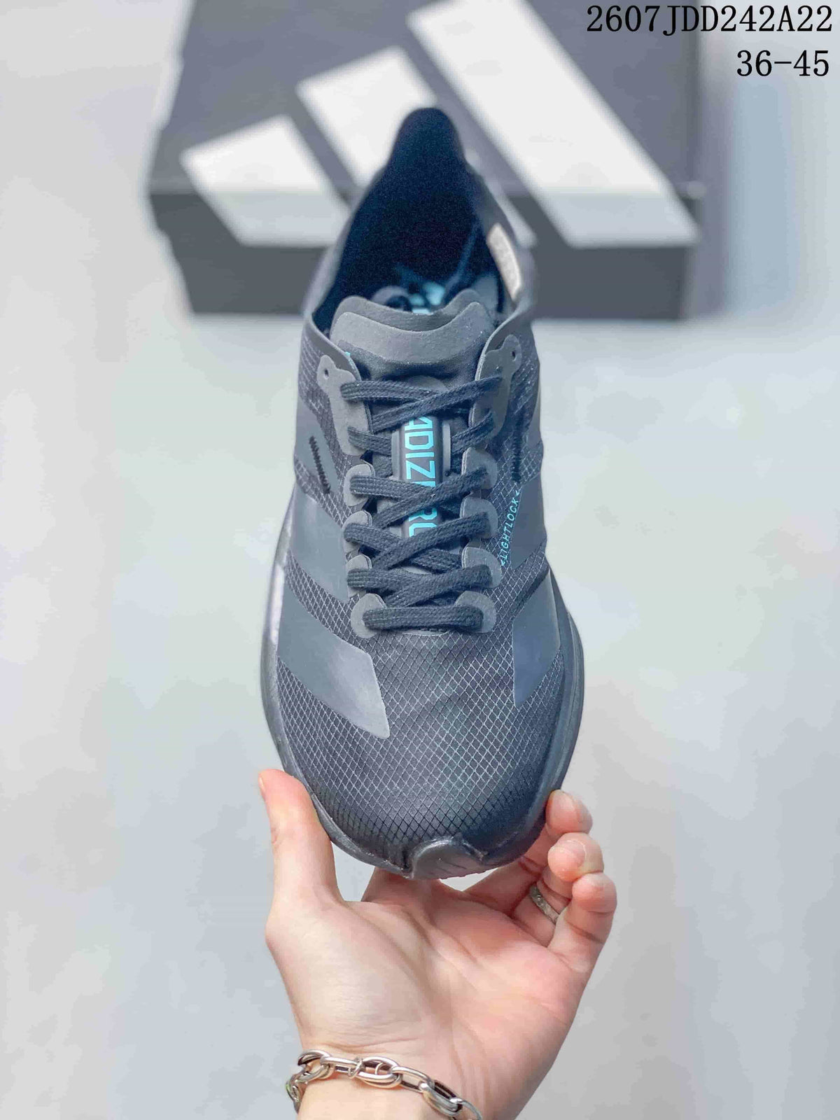Top view showing the dark gray textured upper, laces, padded tongue, and turquoise tongue detail.