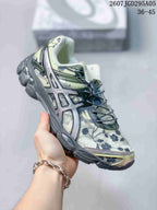 Angled side view of the ASICS sneaker showing the floral upper, structured overlays, padded collar, and charcoal outsole.