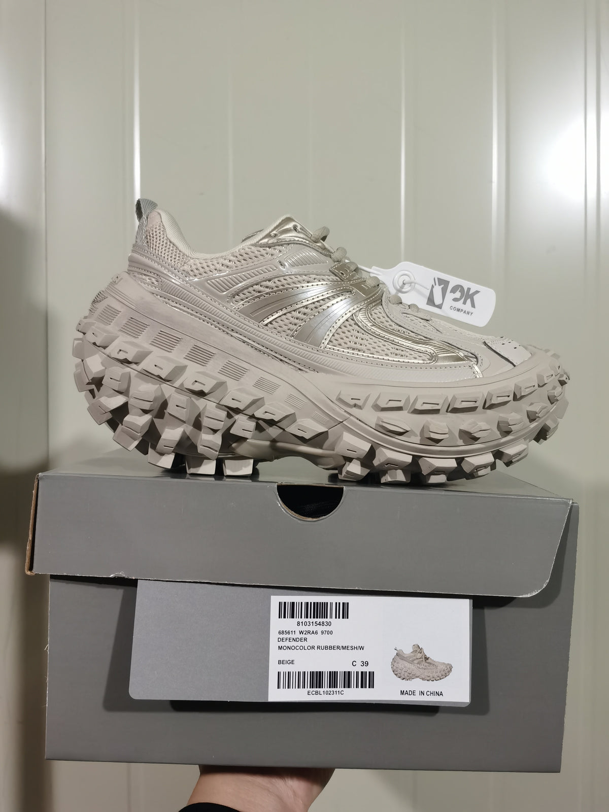 Beige sneaker displayed on its box; the label shows 9700, Defender, W2RA6, beige, and sample size C 39.