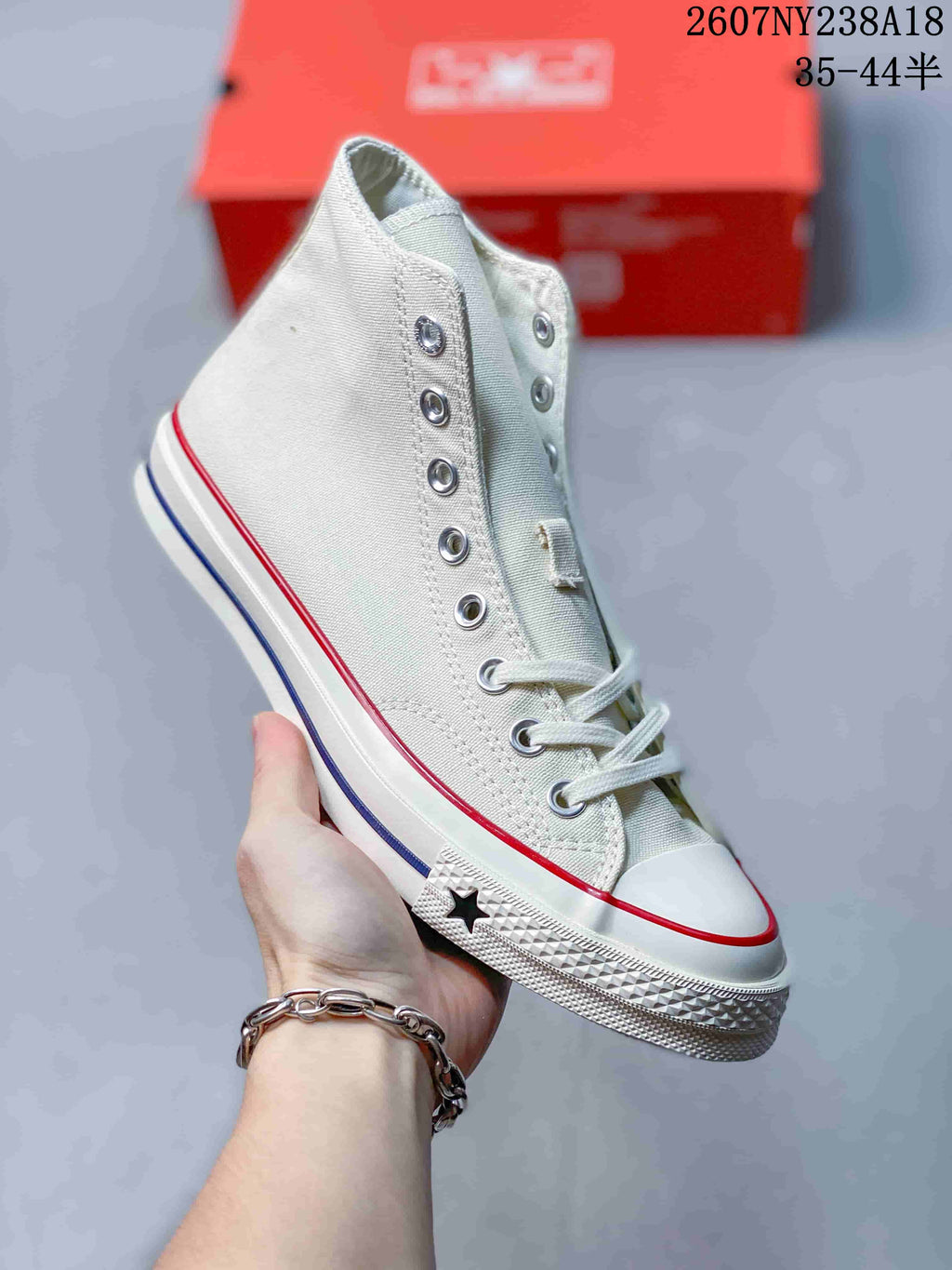 Angled side view of an off-white Converse high-top sneaker showing the ankle area, metal eyelets, textured rubber sole, and star sidewall detail.
