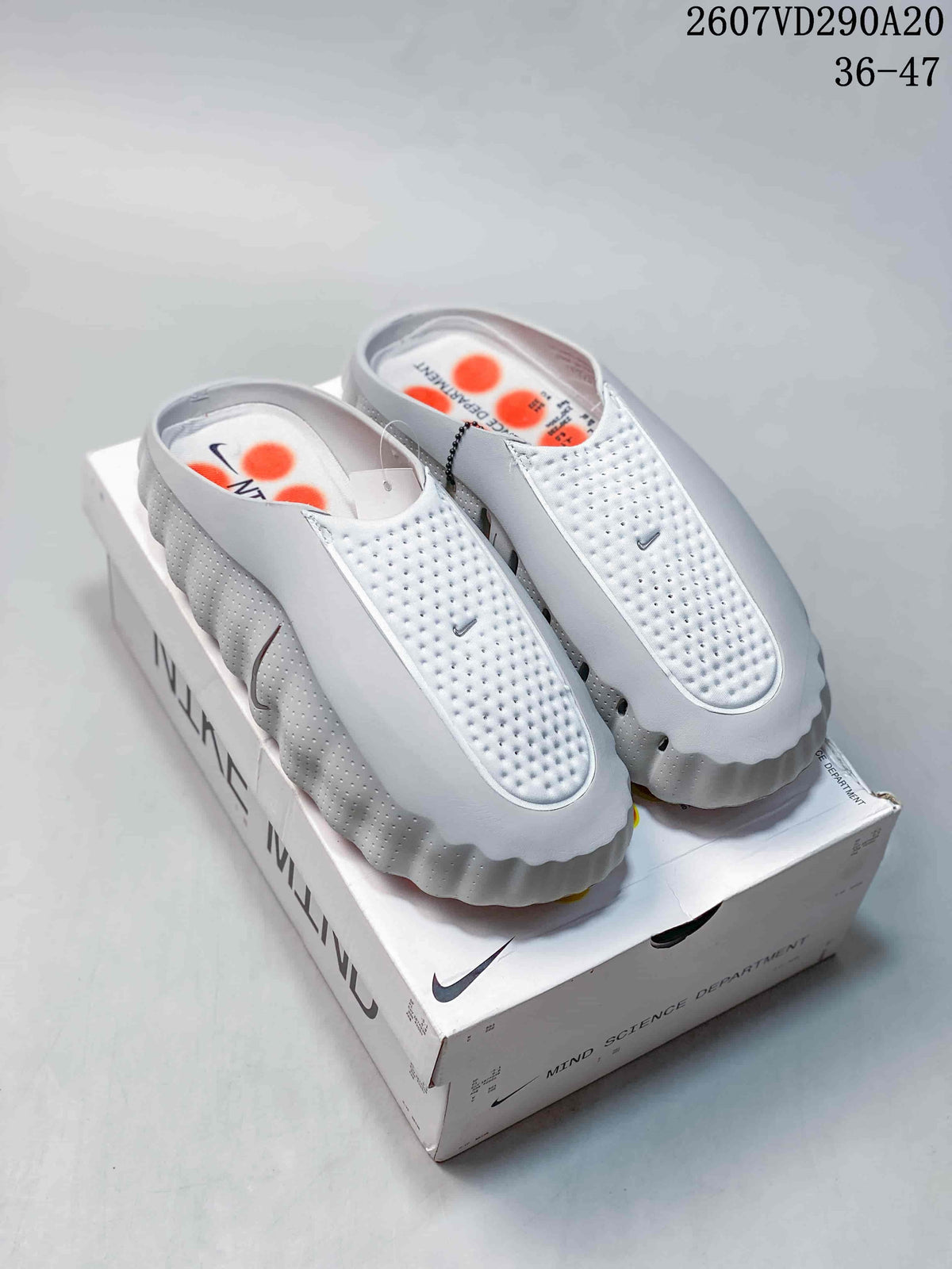 White Nike Mind 001 covered-toe slides displayed on a branded box; image text shows style code 2607VD290A20 and EU size range 36–47.