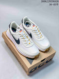 Pair of white Nike ACG sneakers with dark side detailing, yellow lace accents, and gum-colored outsoles displayed on an ACG shoe box.