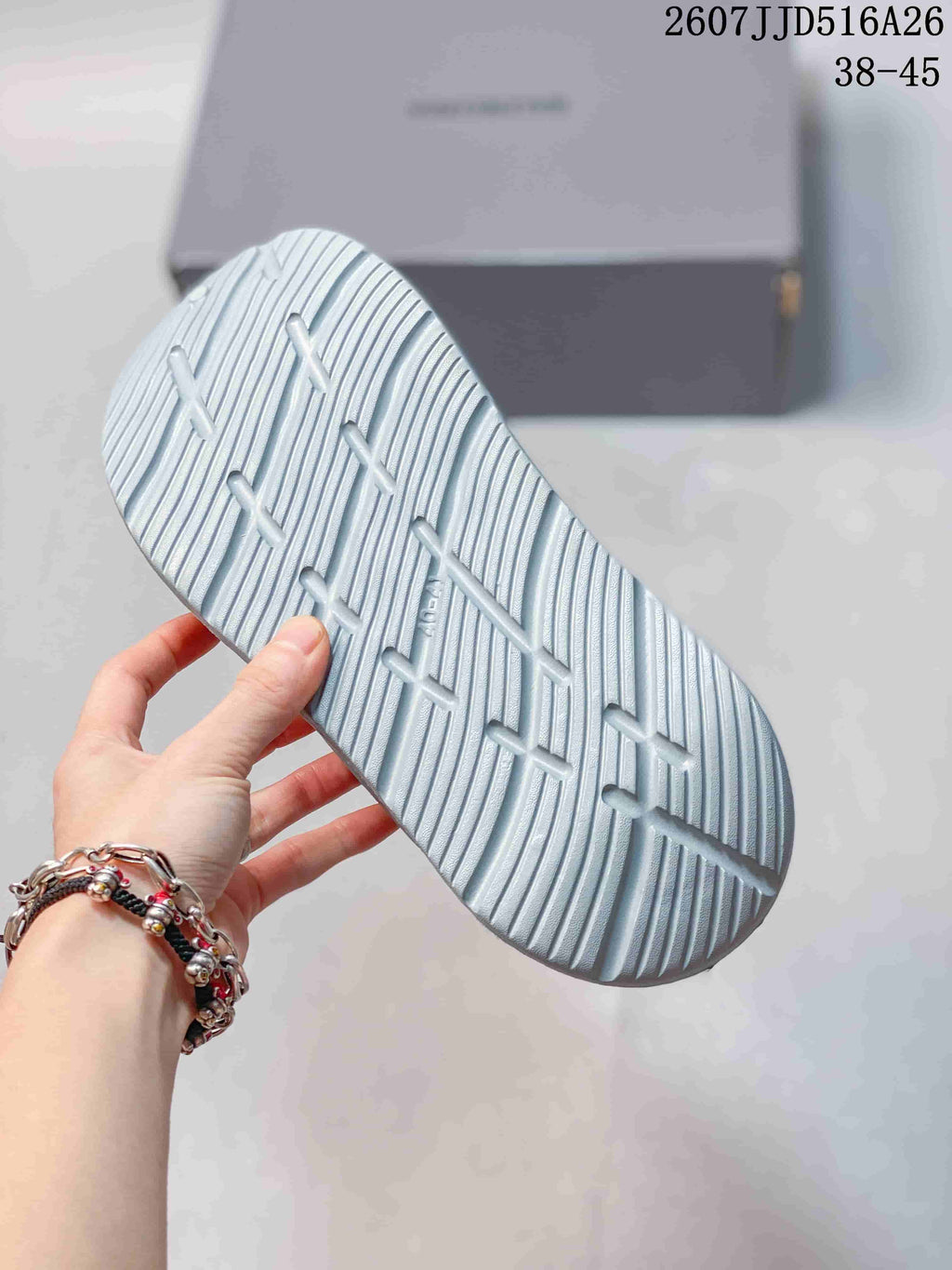 Close view of the sandal outsole showing raised linear tread and a textured traction pattern.