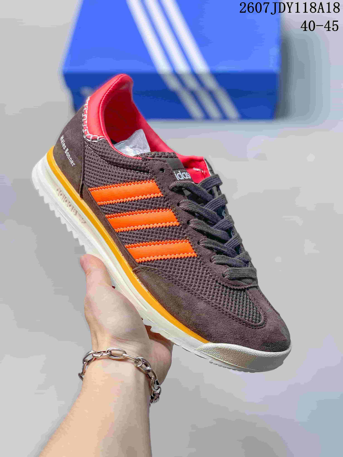 Dark brown adidas SL 72 sneaker with bright orange stripes and a yellow-edged outsole.