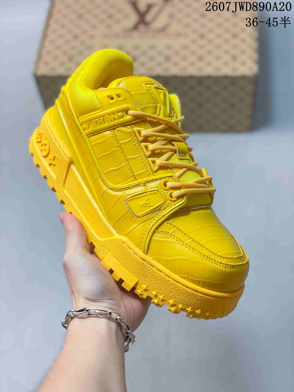 Three-quarter view of the yellow Louis Vuitton Trainer Maxi sneaker showing the layered upper, laces and thick outsole.
