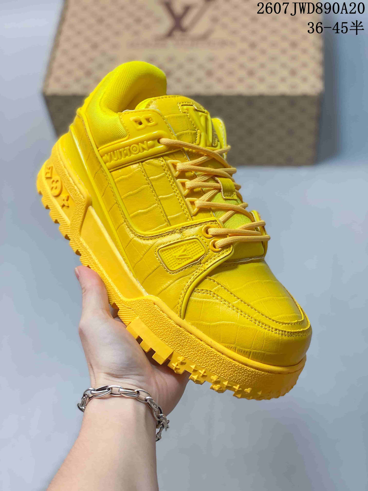 Three-quarter view of the yellow Louis Vuitton Trainer Maxi sneaker showing the layered upper, laces and thick outsole.