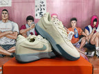 Angled view of a pair of light beige Nike shoes with gray and teal accents.