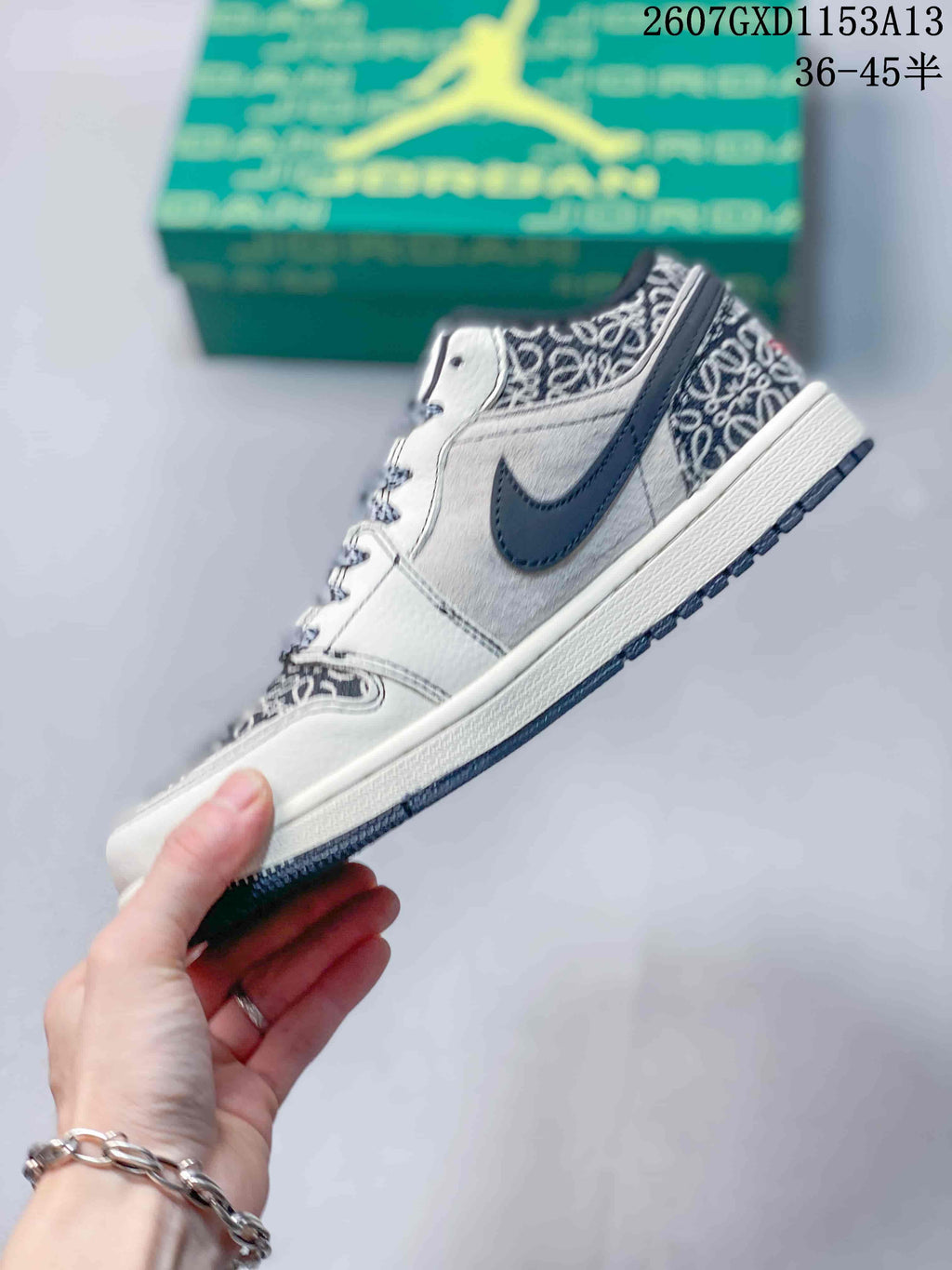 Side profile showing the white and grey upper, navy Swoosh, patterned heel section, and dark outsole.