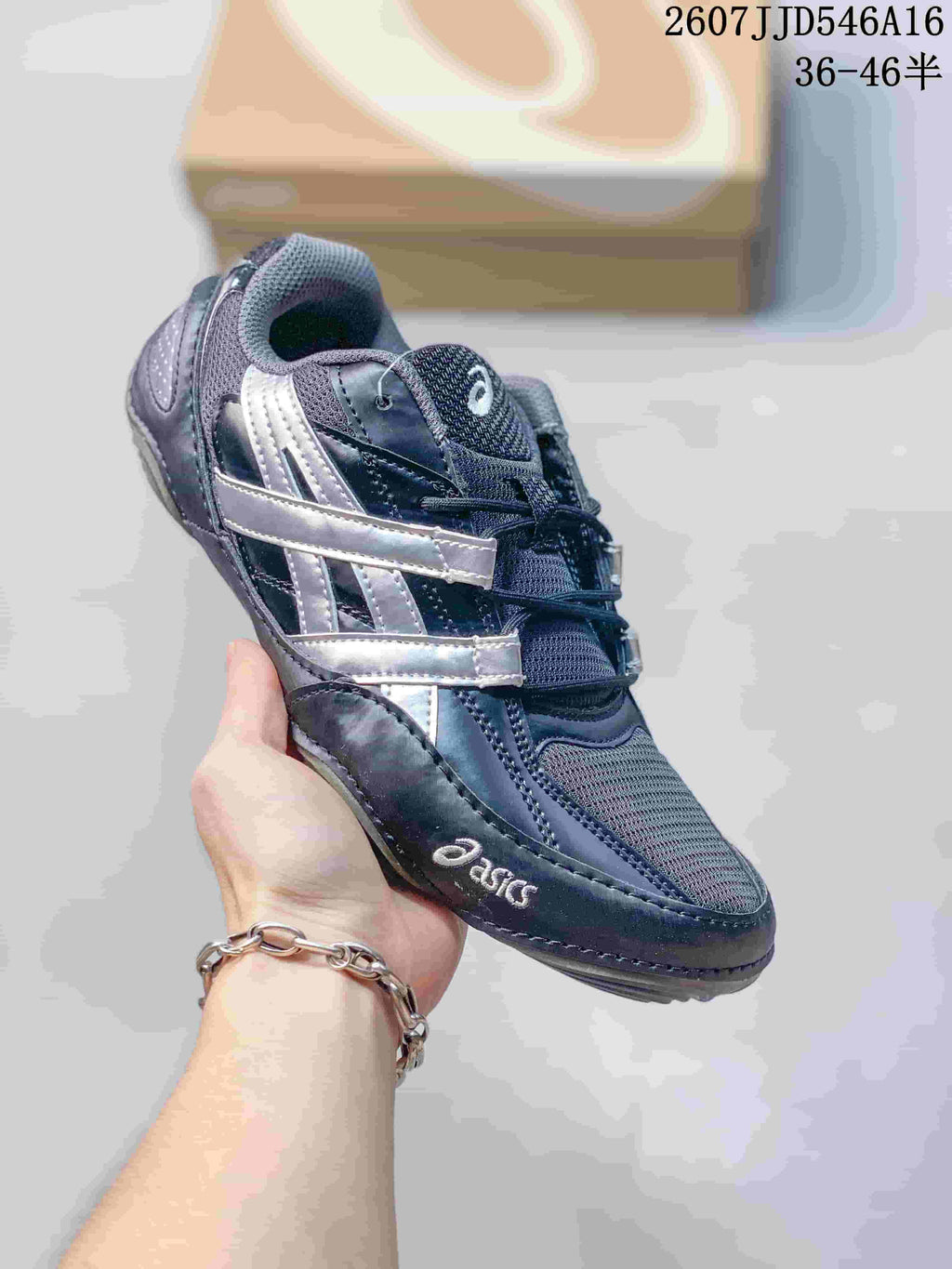 Close side view of a dark navy and silver ASICS Hypersync sneaker with mesh panels and reflective-looking side accents.