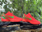 Pair of red and green Nike Kobe 6 shoes shown from the side