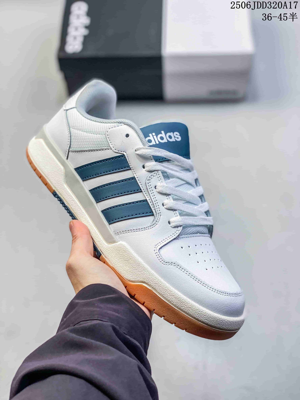 White adidas Entrap sneaker with blue side stripes and a gum-colored outsole, shown with its box.