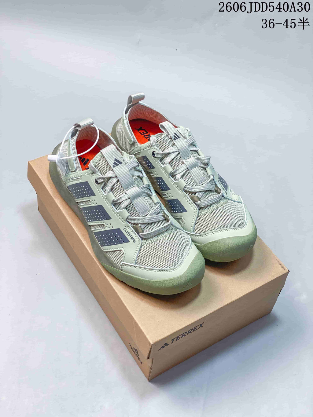 Pair of pale sage-green Adidas Terrex sneakers displayed on a box