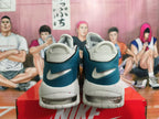 Rear view of white and teal Nike basketball shoes with speckled midsoles and visible heel air units.