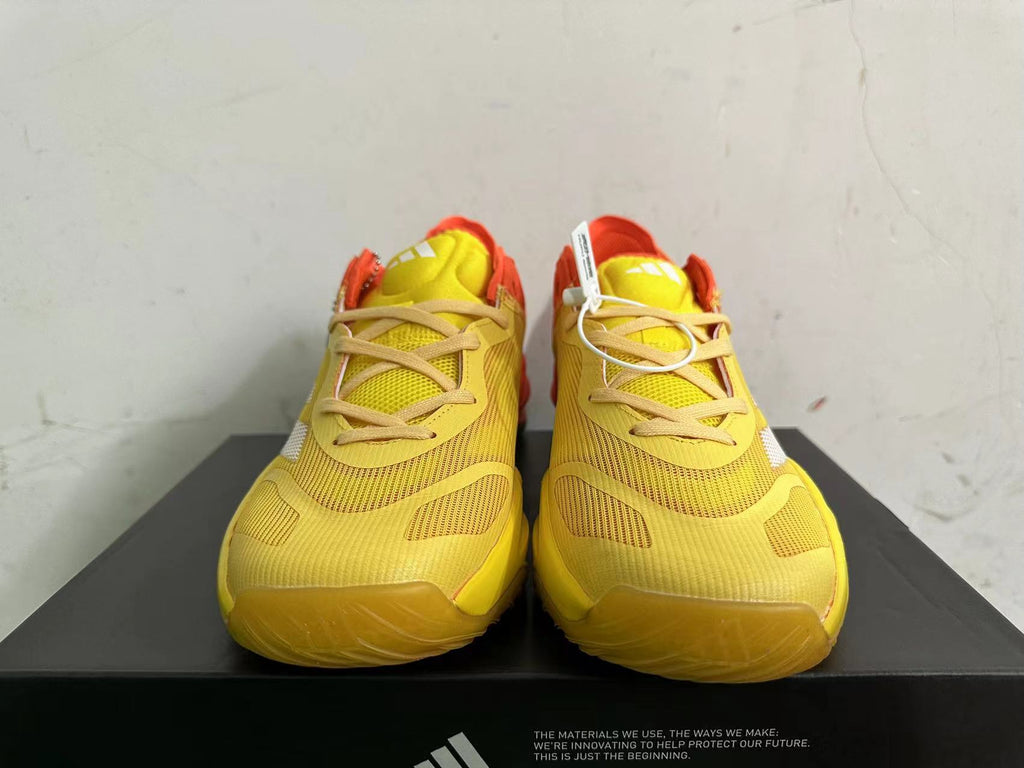Front view showing the yellow lace-up upper and orange details of Adidas Adizero shoes
