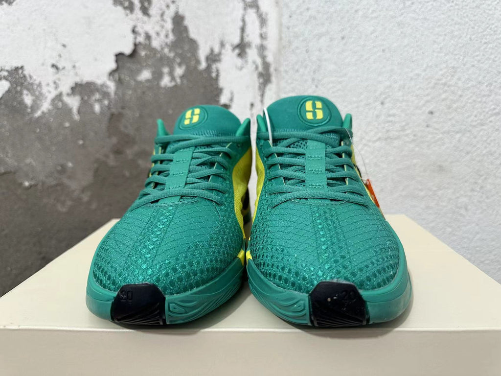 Front view showing green patterned toes, green laces, and yellow tongue logos.