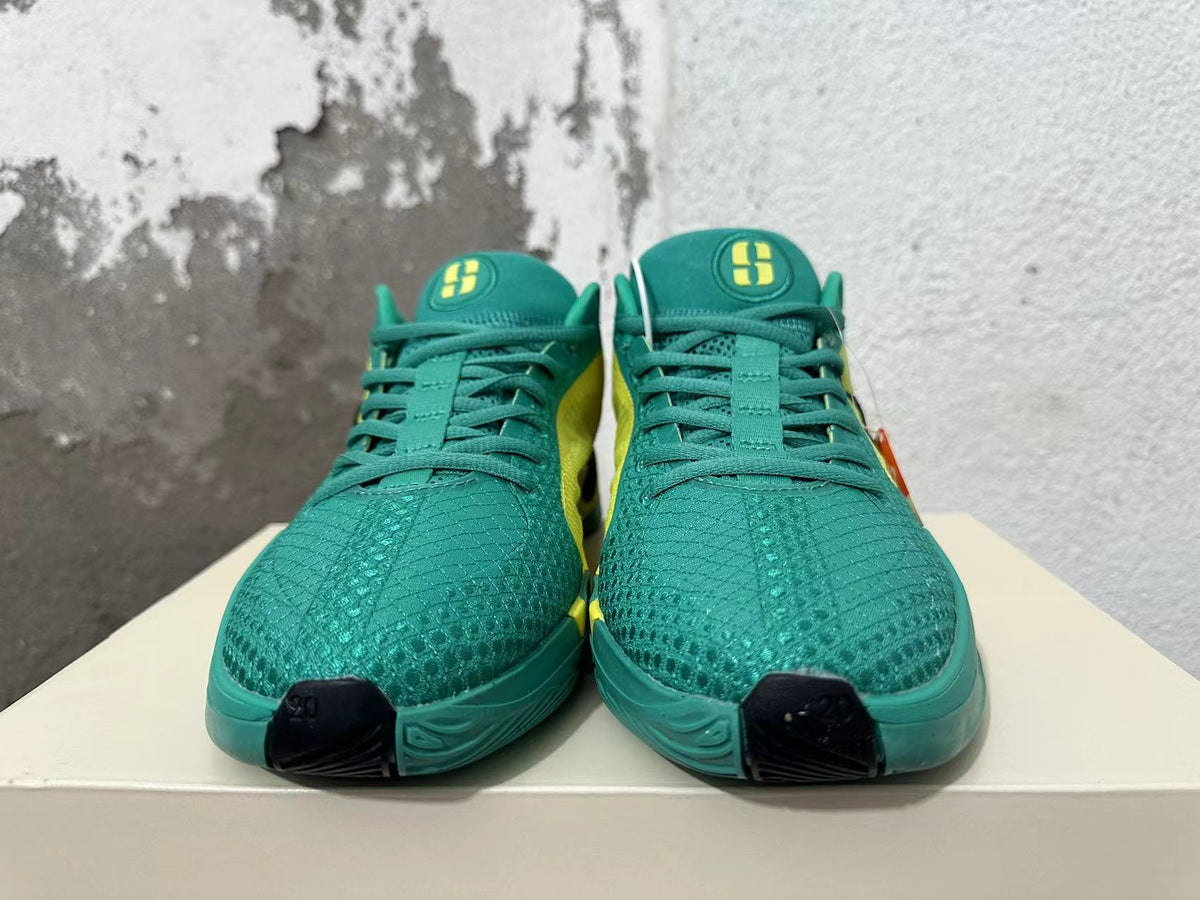 Front view showing green patterned toes, green laces, and yellow tongue logos.