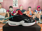 Side profile of a black and red Jordan sneaker with a white midsole and heel window.