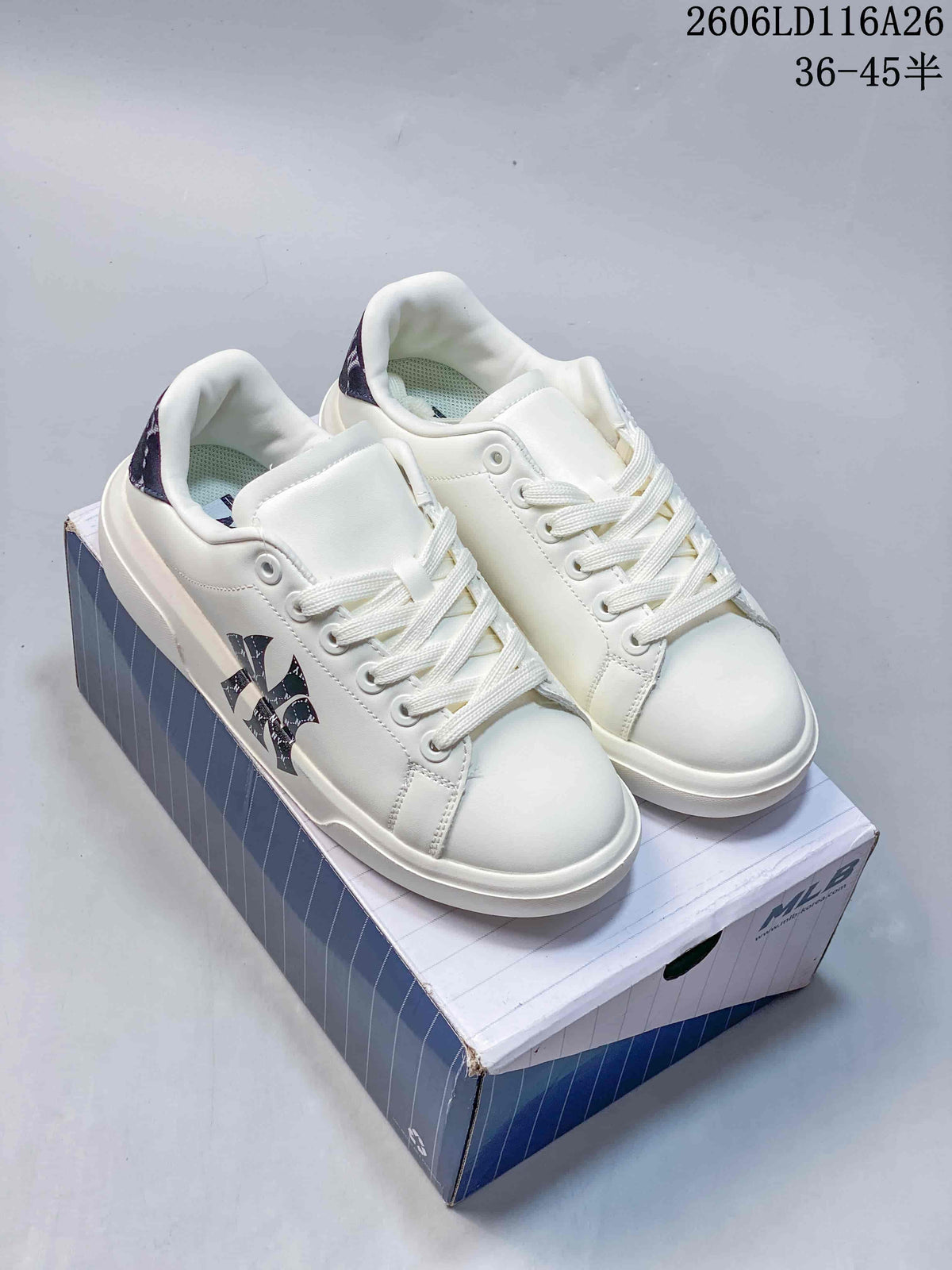 Pair of white MLB low-top sneakers with navy and black graphic details, shown on a blue-and-white shoebox.