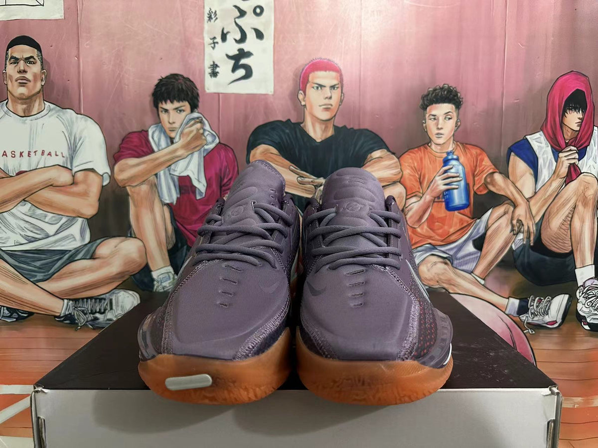 Front view of purple Nike GT Cut 3 basketball shoes with orange gum-colored outsoles.