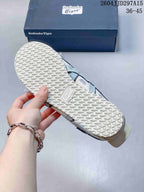 Underside view showing the repeating textured rubber outsole and Onitsuka Tiger branding on the shoe box.