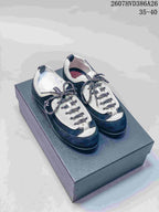 Pair of black and white low-top sneakers photographed from above on a dark shoe box.