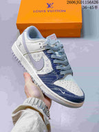 Close-up of a white sneaker with blue denim-look panels, gray laces, and patterned details.