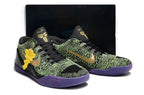Pair of black, green, and purple basketball shoes with a dark box behind them.