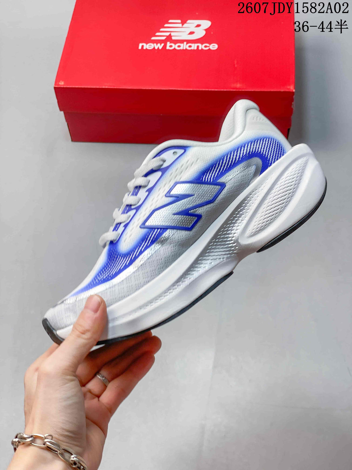 Side view of a white and blue New Balance running shoe